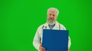 Sağlık ve tıbbi danışmanlık reklam konsepti. Krom anahtar yeşil ekranda insan sıhhiyesinin portresi. Beyaz önlüklü kıdemli doktor konuşuyor, işaret ediyor..