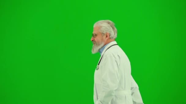 保健和医疗咨询广告概念 彩色键绿色屏幕上的男性医生画像 侧视近距离拍摄资深医生散步和友好问候周围的人 — 图库视频影像