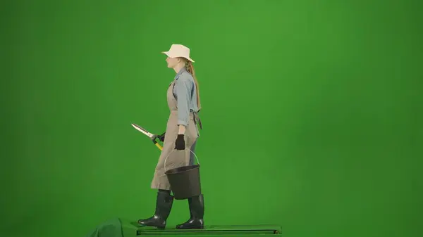 农业和自然耕作创意广告概念 农民穿着工作服在彩色键绿色屏幕上的肖像 园艺师提着剪刀和桶走在路上 — 图库照片