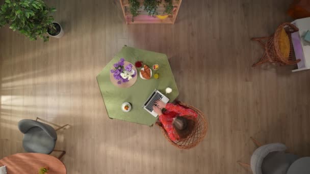 在顶部的镜框里 有一个年轻姑娘坐在咖啡厅的桌旁 她打印 看她的笔记本电脑 浏览网站 社交网络 桌上有甜点 还有一杯果汁 — 图库视频影像