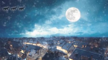 Dağlardaki kış köyü. Güzel bir Noel manzarası. Gökyüzünde dolunay var ve kar yağıyor.