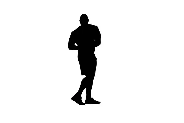 在镜头中 一个男人站在一个白色背景的轮廓上 他是一名运动员 健美运动员 健美运动员 展示他的身体 二头肌和肌肉 他弯着胳膊看着摄像机 — 图库照片