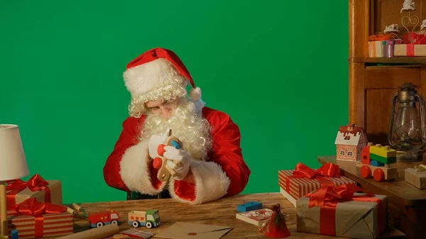 Santa Claus Vid Bordet Med Presenter Och Göra Trä Leksak — Stockfoto