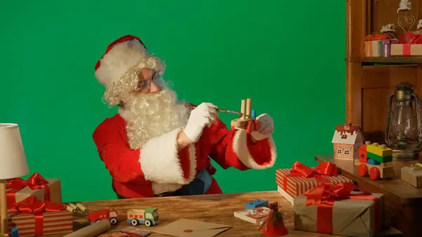 Noel Baba Hediyelerle Masada Yeşil Arka Planda Tahta Bir Oyuncak — Stok fotoğraf