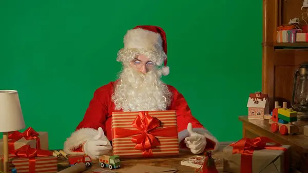 Άγιος Βασίλης Στο Τραπέζι Δώρα Και Κοιτάζοντας Ένα Κουτί Ένα — Φωτογραφία Αρχείου