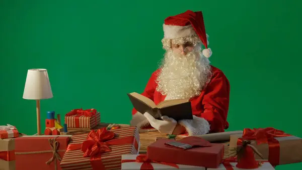Άγιος Βασίλης Στο Τραπέζι Δώρα Και Διαβάζοντας Ένα Βιβλίο Παραμύθια — Φωτογραφία Αρχείου
