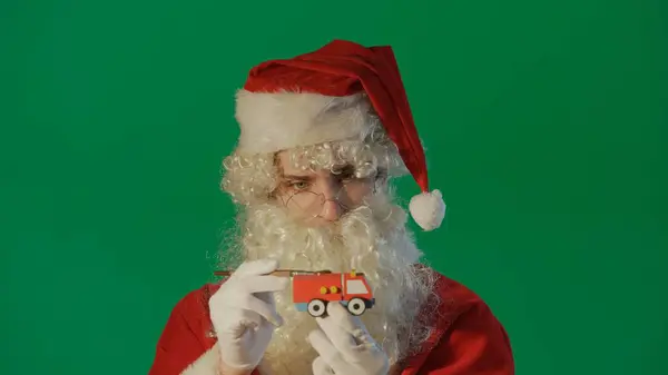 Portret Świętego Mikołaja Malujący Samochód Prezentem Zielonym Tle — Zdjęcie stockowe