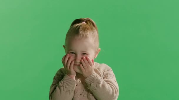 カメラを見て驚いた小さな幼稚園の少女の肖像画は予期せぬ良いニュースに驚き グリーンスタジオの背景に隔離された信じられないほどの驚きに衝撃を受けた幸せなかわいい小さな子供に驚かされます — ストック動画