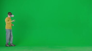 Modern çocuk okulu ve eğlence zamanı reklam konsepti. Krom anahtar yeşil ekrandaki çocuk portresi. Sanal gerçeklik gözlüklü okul çocuğu etrafta dolaşıp oyun oynuyor..