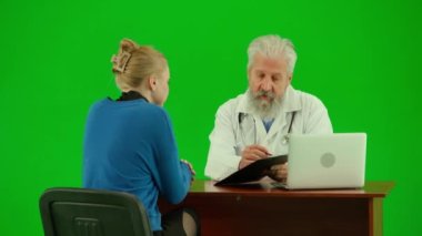 Sağlık ve tıbbi danışmanlık reklam konsepti. Krom anahtar yeşil ekranda insan sıhhiyesinin portresi. Üniformalı kıdemli doktoru kapatın. Masada kadın hastalarla birlikte kağıt belgeler gösteriyorlar.