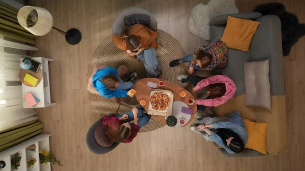 一群坐在客厅里的女学生的头像 年轻的妇女们坐在桌子旁边 桌子上有一个披萨盒和装有风饮料的纸杯 青年的概念 — 图库照片
