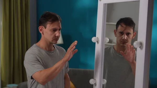 精神障害に苦しむ男性は 鏡の前に立って 手のひらに顔を隠しています アパシー 内なる葛藤 心理的な問題 — ストック写真