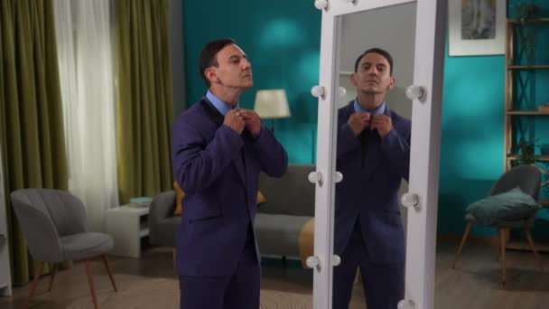 厳格なスーツを着た男が 鏡の前にリビングルームに立っている 男は自分自身に話しかけ 自分を応援している スプリットパーソナリティ — ストック動画