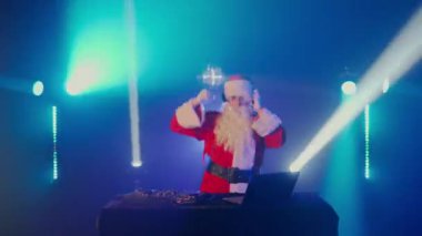 Noel Baba DJ 'i Noel ve Yeni Yıl partisinde ya da kurumsal etkinliklerde bir gece kulübünde şarkı karıştırıyor. Son sınıf disk jokeyi. Müzik, kulaklık, dizüstü bilgisayar, mikser çalar, turntable çalar.