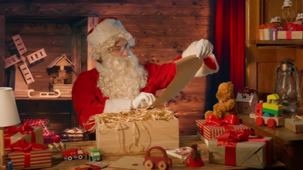 Санта Клаус Столом Подарунками Читання Листа Його Будинку — стокове відео