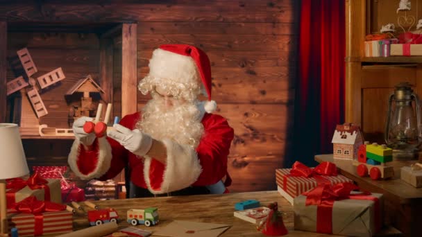 Kerstman Aan Tafel Met Geschenken Het Maken Van Een Houten — Stockvideo