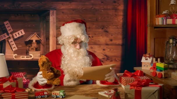 Kerstman Aan Tafel Met Geschenken Het Lezen Van Een Brief — Stockvideo