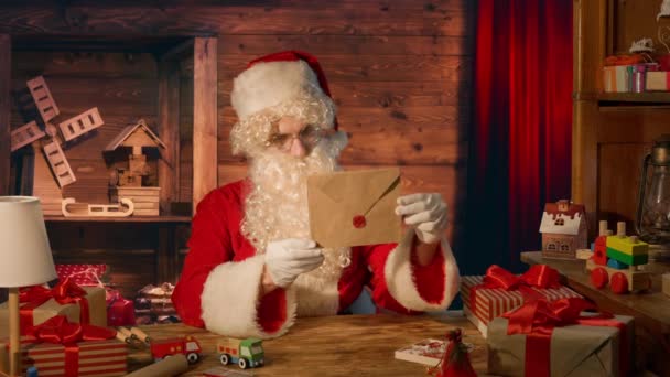 Jultomten Vid Bordet Med Presenter Och Läsa Ett Brev Hemma — Stockvideo