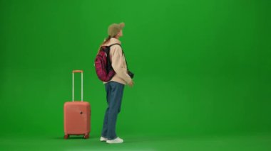 Uçak kreatif havaalanı reklam konseptiyle seyahat etmek. Krom anahtar yeşil ekran arka planında izole edilmiş gezgin portresi. Elinde bavuluyla fotoğraf çeken genç bir kız..