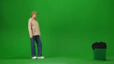 Uçak kreatif havaalanı reklam konseptiyle seyahat etmek. Krom anahtar yeşil ekran arka planında izole edilmiş gezgin portresi. Genç kız valiziyle ilgili güvenlik görevlisiyle konuşuyor..
