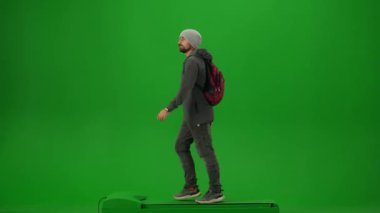 Uçak kreatif havaalanı reklam konseptiyle seyahat etmek. Krom anahtar yeşil ekran arka planında izole edilmiş gezgin portresi. Sırt çantalı, şapkalı genç adam yürüyor ve etrafa bakıyor..