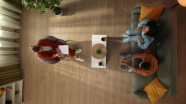 Aile psikoterapisi ve yaratıcı akıl sağlığı konsepti. Terapi seansında evli bir çiftin üst görüntüsü. Bir çift kanepede oturur ve psikoterapistle görüşürken mutlu mesut iletişim kurar.