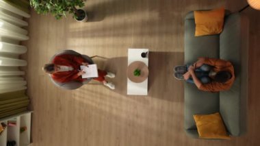 Aile psikoterapisi ve zihinsel sağlık yaratıcı konsepti. Terapi seansındaki en iyi erkek görüntüsü. Kanepede oturup psikoterapist dinleyen, depresif, endişeli, yastığa sarılan bir adam..