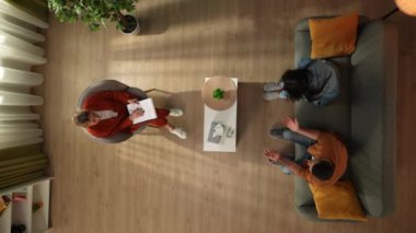 Aile psikoterapisi ve yaratıcı akıl sağlığı konsepti. Terapi seansında evli bir çiftin üst görüntüsü. Kadın ağlar, erkek onu sakinleştirir ve ona bir bardak su ikram eder.