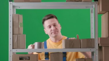 Yeşil arka planda çerçevelenmiş, kromakey. İfade, üniformalı bir adamdır. İfadeler bir depoda depo görevlisi. Elinde bir bardak tutuyor ve vites değiştiriyor, bir kutu arıyor ve bir içecek içiyor. Orta çerçeve