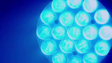 Videoda bir gece kulübünün karanlığını kesen bir çift yoğun mavi sahne ışığı görülüyor. Güçlü ışınlar dramatik ve karamsar bir atmosfer yaratıyor. Canlı müzik mekanı ya da dans için tipik bir ortam.