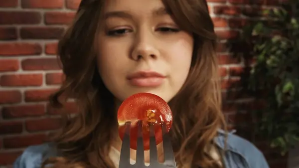熟した赤い桜のトマトの半分のフォークを見ている女の子の近く クリエイティブ食品広告コンセプト パブリック — ストック写真