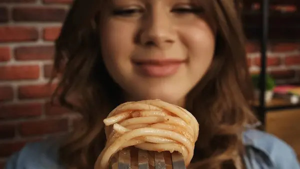 走近一个女孩 她看着一个叉子里有意大利面和番茄酱 食品广告的创意概念 Pov — 图库照片