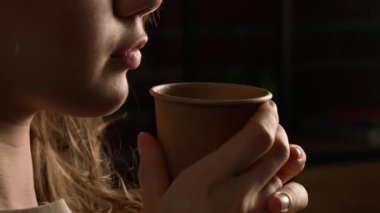Aşırı gurme bakış açısı yaratıcı reklam konsepti. Yakından çekilen kişi farklı lezzetli yemeklerden zevk alır. Genç kız ağzının yanında bir fincan sıcak kahve tutuyor, taze sabah içeceği soluyor..
