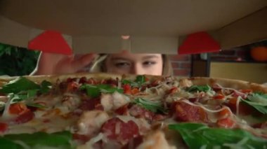 Aşırı gurme bakış açısı yaratıcı reklam konsepti. Farklı lezzetli yiyecekler yiyen insanlara yakın çekim. Konteynırdan bakınca, kız pizza kutusunu açıyor, şaşkın bir yüz ifadesi var. POV.