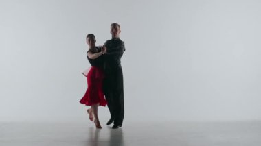 Beyaz arka planda Siluet, Zarif Balo Dansı Çifti. Minimalist bir ortamda poz verirken yakalanan çağdaş bir balo dansçısı çiftin çarpıcı videosu. Bağlantıları ve akıcılıkları...