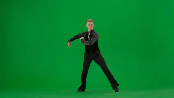 Ballroom Dancer Poised for Performance on Green Screen. A confident ballroom dancer stands poised in a classic dance stance, ready to begin his routine. Dressed in professional dance attire against a