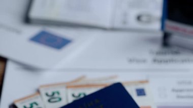 Pasaport ve göç yaratıcı reklam konsepti. Bir kimlik belgesini kapat. Belgeler ve Ukrayna pasaportu. Masada duran kapalı avro banknotları.