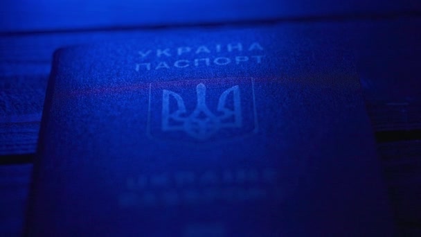 パスポートと移行クリエイティブ広告コンセプト アイデンティティ文書を閉じる ブルーライトのテーブルに国のシンボルを持つブルーウクライナのパスポート — ストック動画