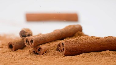 Aromatik baharatlar yaratıcı reklam konsepti. Yemek malzemelerinin stüdyo çekimlerini kapat. Beyaz arka planda duran kahverengi kurutulmuş tarçın çubukları yığını..
