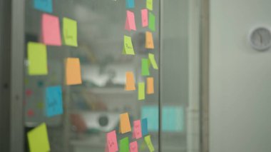 Modern iş dünyasının yaratıcı konseptinde beyin fırtınası ve fikirler. Notlar üzerine proje planlama. Üzerinde kelimeler yazılı renkli yapışkan notlar olan cam duvar.