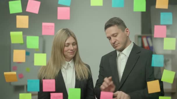 现代企业创新理念中的头脑风暴和创意 公司领导在办公室规划项目中的形象记录 商界男女在玻璃墙上贴上粘贴的便条 竖起大拇指 — 图库视频影像