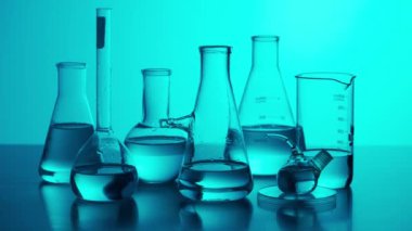 Bilim ve biyoteknoloji yaratıcı kavramı. Neon arka planda tıbbi cam örtüyü kapatın. Mavi neon ışık deneyleri için çeşitli deney tüpleri ve sıvı deney tüpleriyle laboratuvar masası..