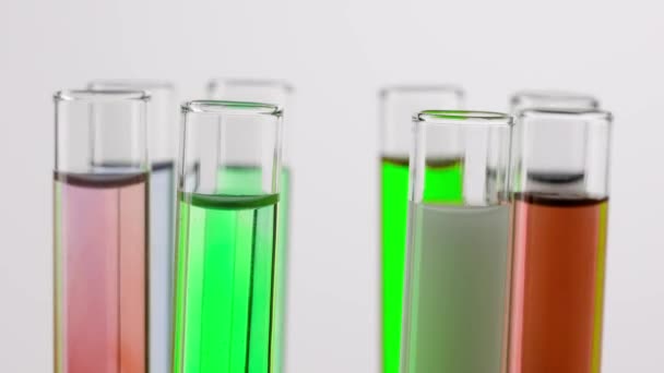 科学和生物技术创意概念 白色背景的实验室玻璃器皿近照 带有五颜六色液体的试管在实验室的平台上旋转 具有科学的专门知识 — 图库视频影像