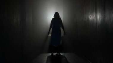 Korku filmi ve kötü ruh yaratıcı reklam konsepti. Evde hayalet kadın portresi var. Yüzü örtülü beyaz elbiseli bir kadın yıldırımla odada yürüyor..