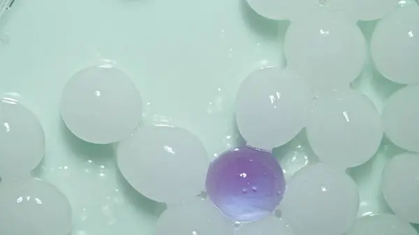 Lots White Hydrogel Spheres One Purple One Green Light Shiny — Stock Photo, Image