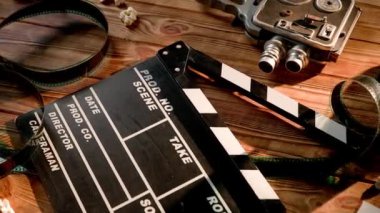 Alkış tahtası, klasik video kamera, sinema filmi ve ahşap masada patlamış mısır taneleri olan 3D gözlükler. Sinematografi Konsepti