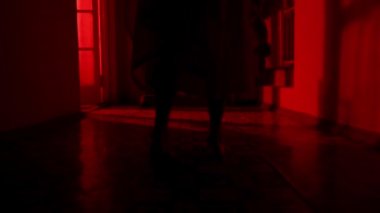 Korku filmi ve kötü ruh yaratıcı reklam konsepti. Evde bir kadın hayalet var. Beyaz elbiseli bir kadın elinde oyuncakla koridorda yürüyor. Yanıp sönen kırmızı korku ışığı. Kapat.