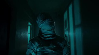 Korku filmi ve kötü ruh yaratıcı reklam konsepti. Evde hayalet insan portresi var. Mumya beyaz kurdelelerle kaplıydı. Koridorda mavi parlayan yıldırımlarla yürüyordu..