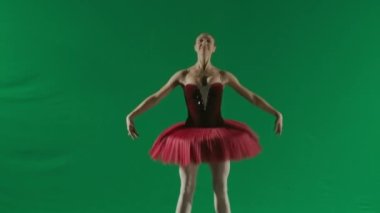 Klasik ve modern bale yaratıcı reklam konsepti. Krom anahtar yeşil ekran arka planında kadın portresi. Kırmızı etekli balerin ve atlama koreografisini gösteren koyu renk vücutlu..