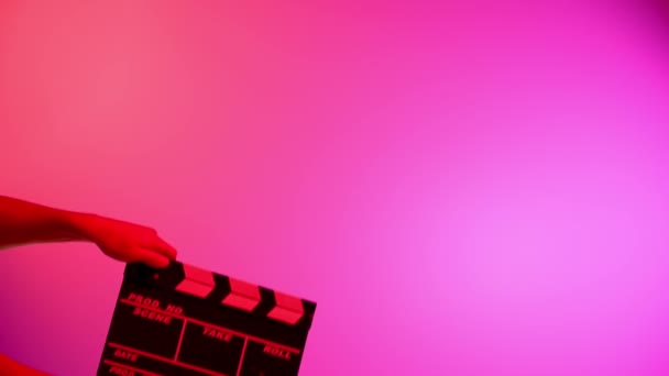 Hand Houdt Black Clapper Board Film Leisteen Een Roze Achtergrond — Stockvideo